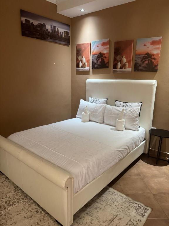 Un dormitorio con una gran cama blanca en una habitación. en Cozy Place in Windhoek, en Windhoek