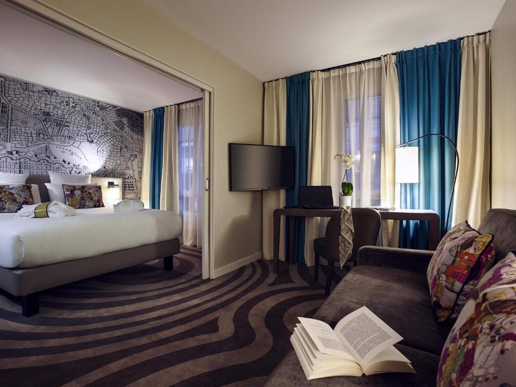a hotel room with a bed and a couch at Mercure Tour Eiffel Grenelle in Paris