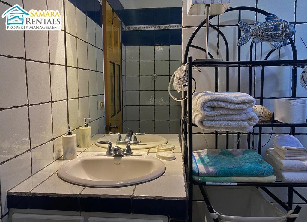 a bathroom with a sink and a mirror and towels at Cozy Apartment Downtown in Nicoya