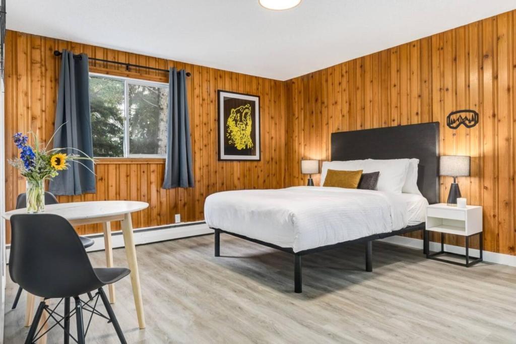 a bedroom with a bed and a desk and a table at Gateway Suites Cozy stay to explore Banff and Canmore in Canmore