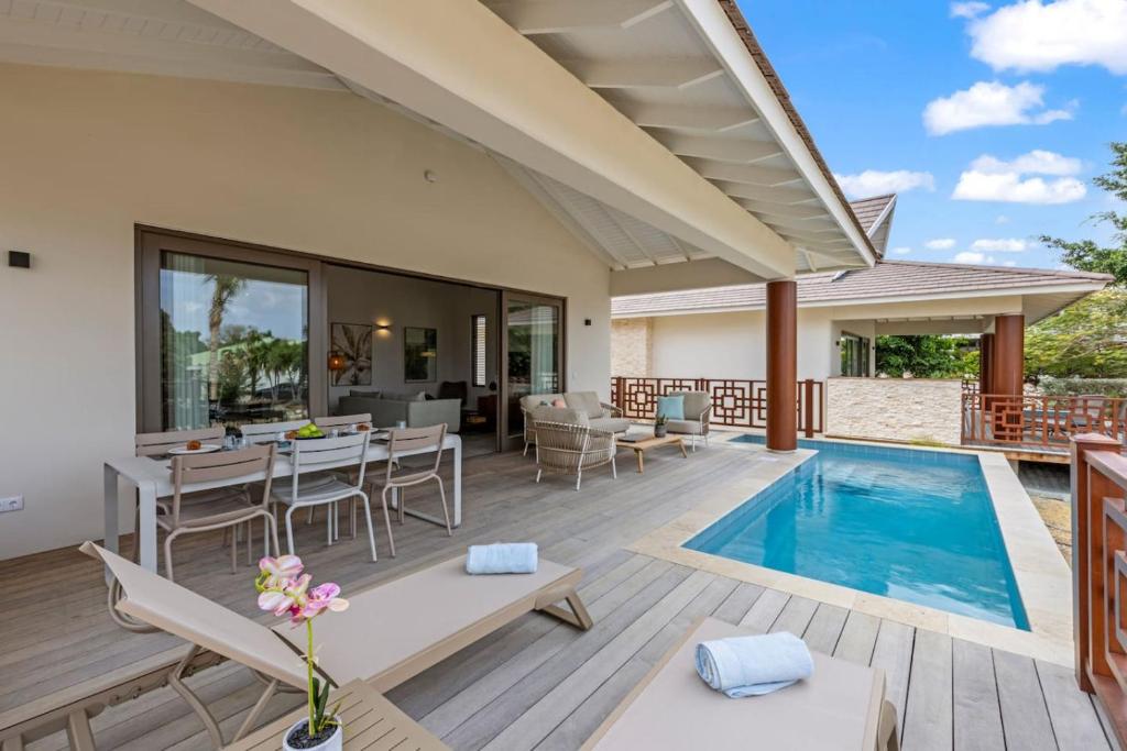a patio with a pool and a table and chairs at Villa Jamzmyn 45, Relaxen met prive plunge pool in Blue Bay