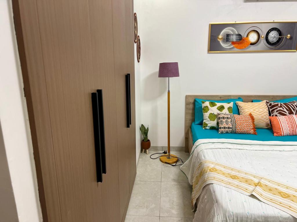 a bedroom with a bed with colorful pillows at LUXES Studio in Dakar