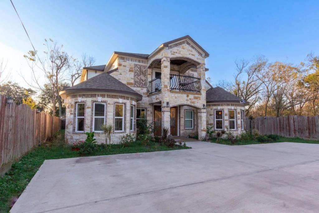ein großes Steinhaus mit einem Holzzaun in der Unterkunft Luxury Spanish Style Getaway in Houston