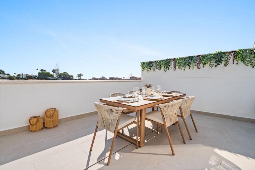 Una mesa y sillas en un balcón con una pared en Sea View Apartment Estepona - Célere Sea Views, en Estepona