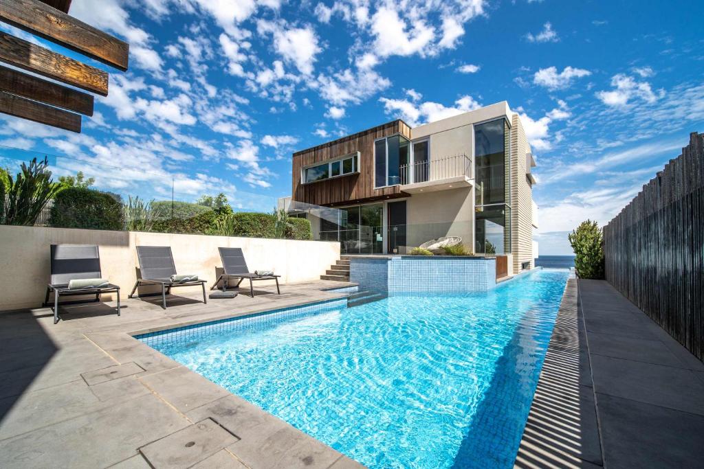 a swimming pool in front of a house at One Eighty Marino in Marino