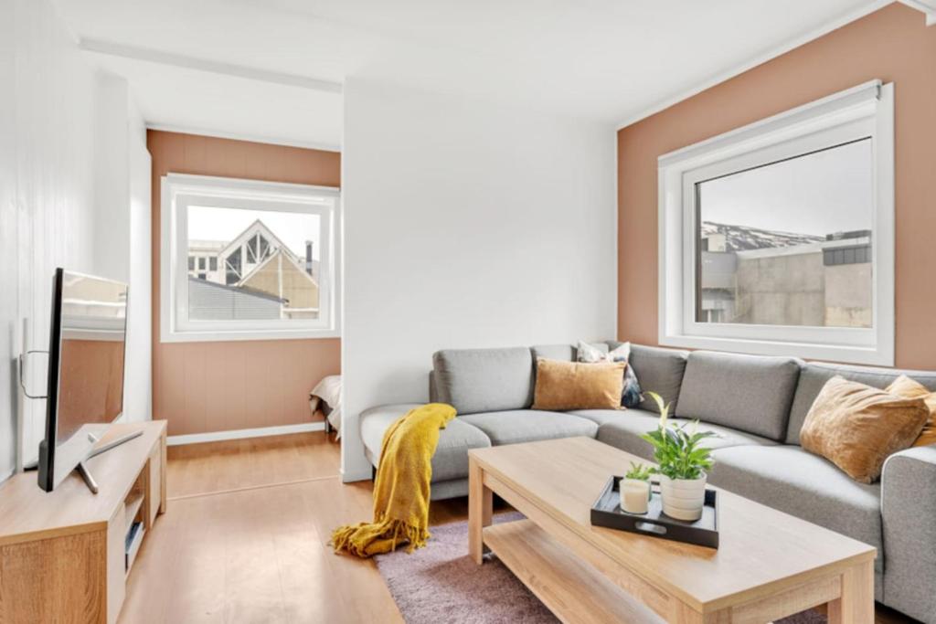 ein Wohnzimmer mit Sofa und Fernseher in der Unterkunft Central and modern studio - close to everything in Guleng