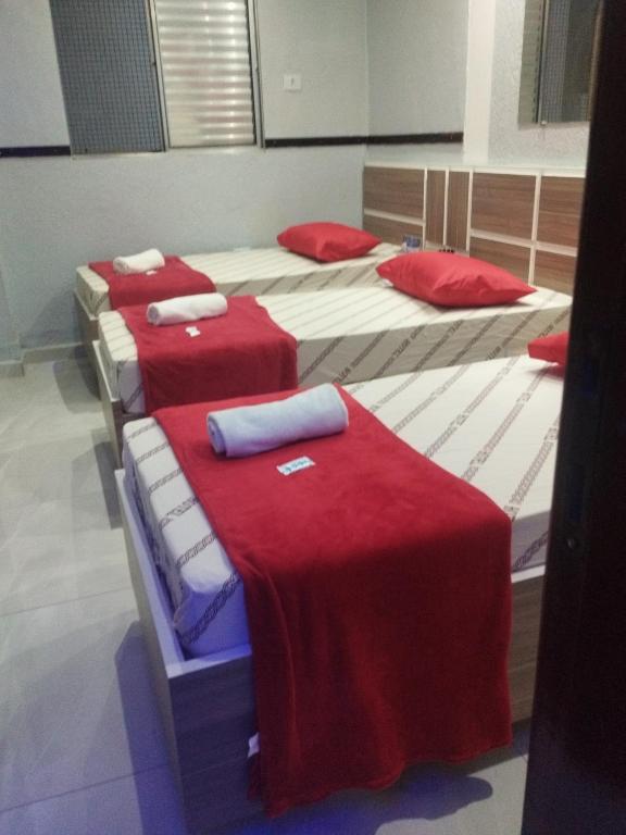 a group of four beds in a room at Hotel Progresso Itaquera - Próximo Arena Corinthians in Sao Paulo