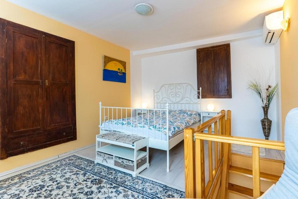a small bedroom with a bed and a wooden door at Holiday house with WiFi Cres - 24872 in Cres