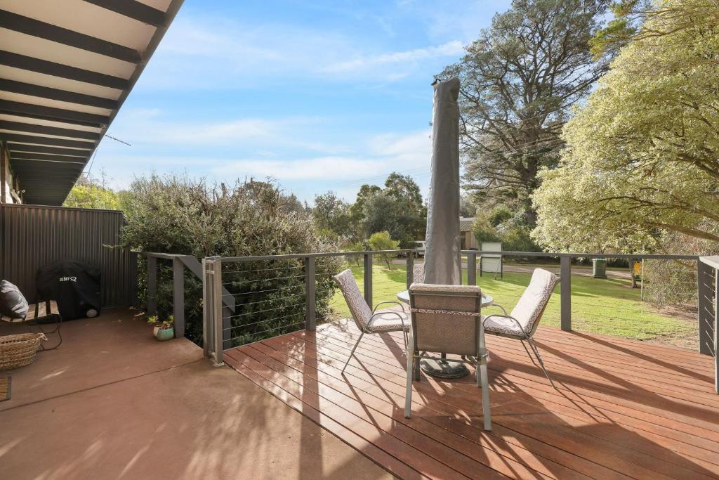 una terrazza con due sedie e un ombrellone di Honeysuckle Beach Haven a Cowes