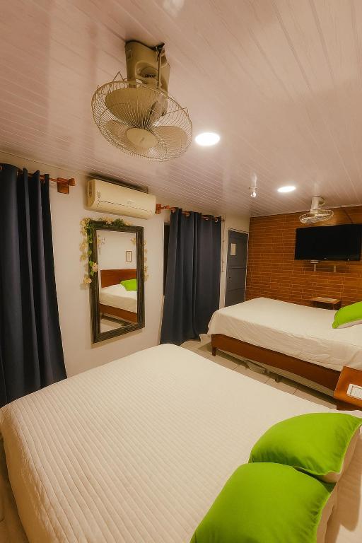 a bedroom with two beds and a television in it at Hostal Leyendas in León