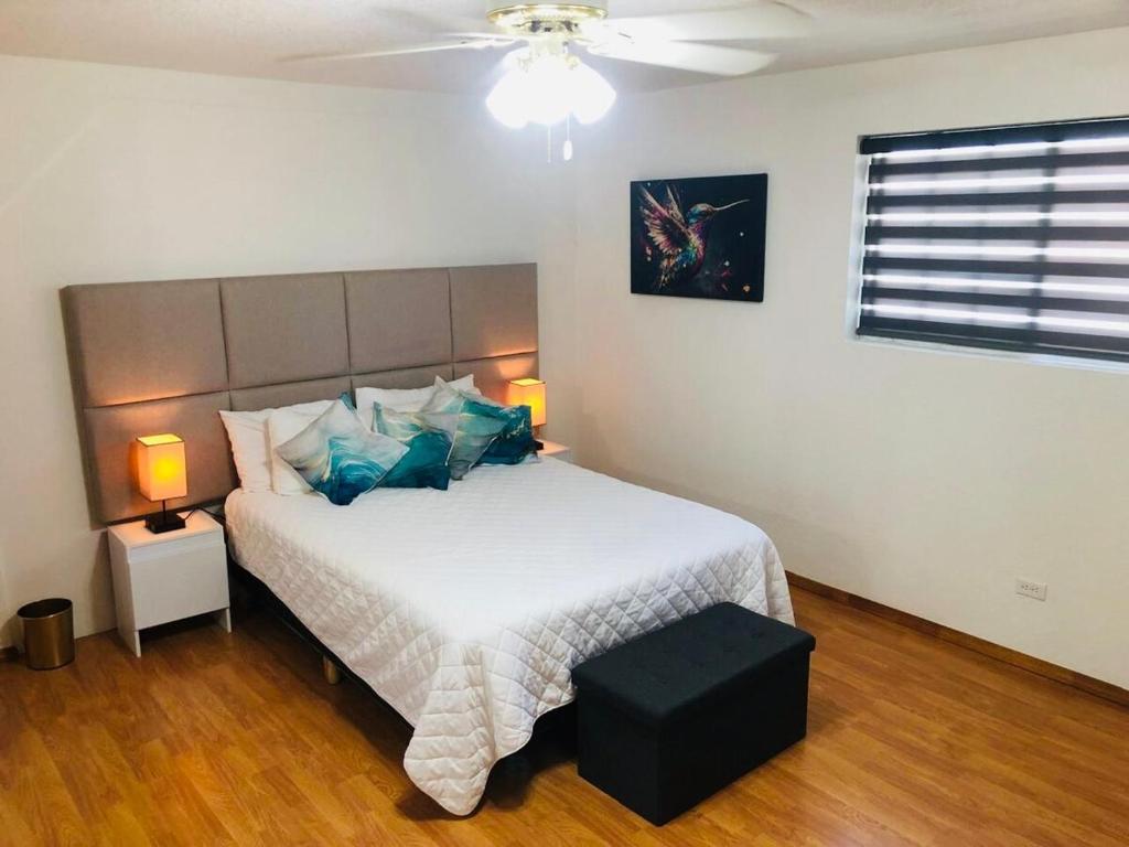 a bedroom with a large white bed with blue pillows at Casa Encanto Ensenada Three Bed Two Bath in Ensenada