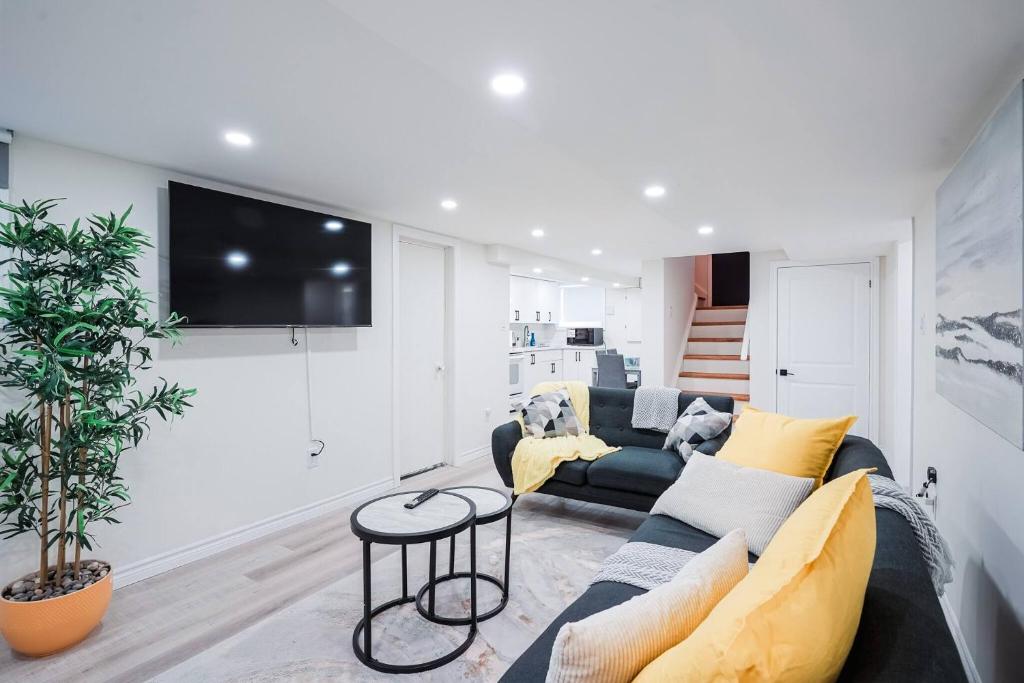 ein Wohnzimmer mit Sofa und Fernseher in der Unterkunft Bright & Cozy Home in the GTA (Basement Apartment) in Whitby