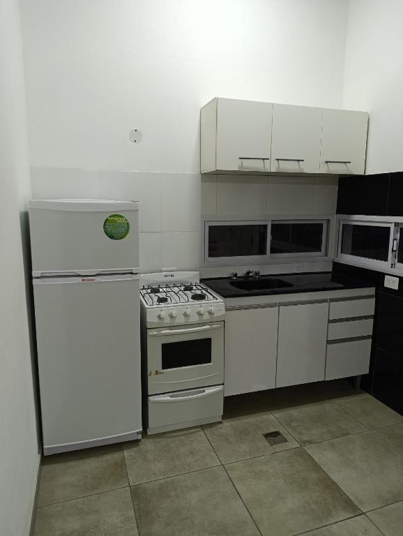 a kitchen with a stove and a refrigerator at Sinaí Apart in Santa Rosa de Calamuchita