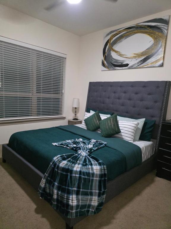 リチャードソンにあるOur Cozy homeのベッドルーム1室(ベッド1台、緑の掛け布団付)