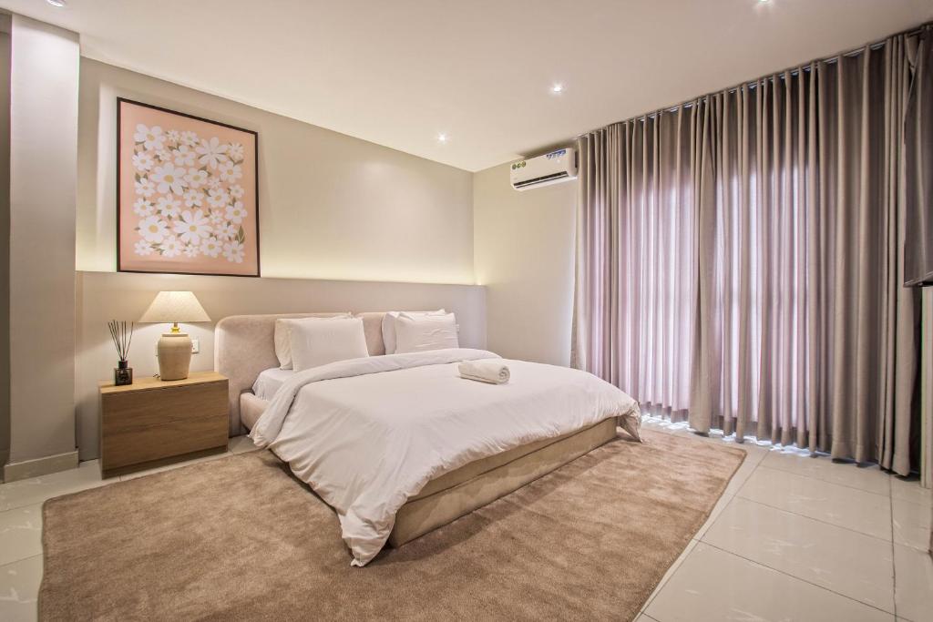 a bedroom with a large bed and a large window at The Metropolis Lekki in Lekki