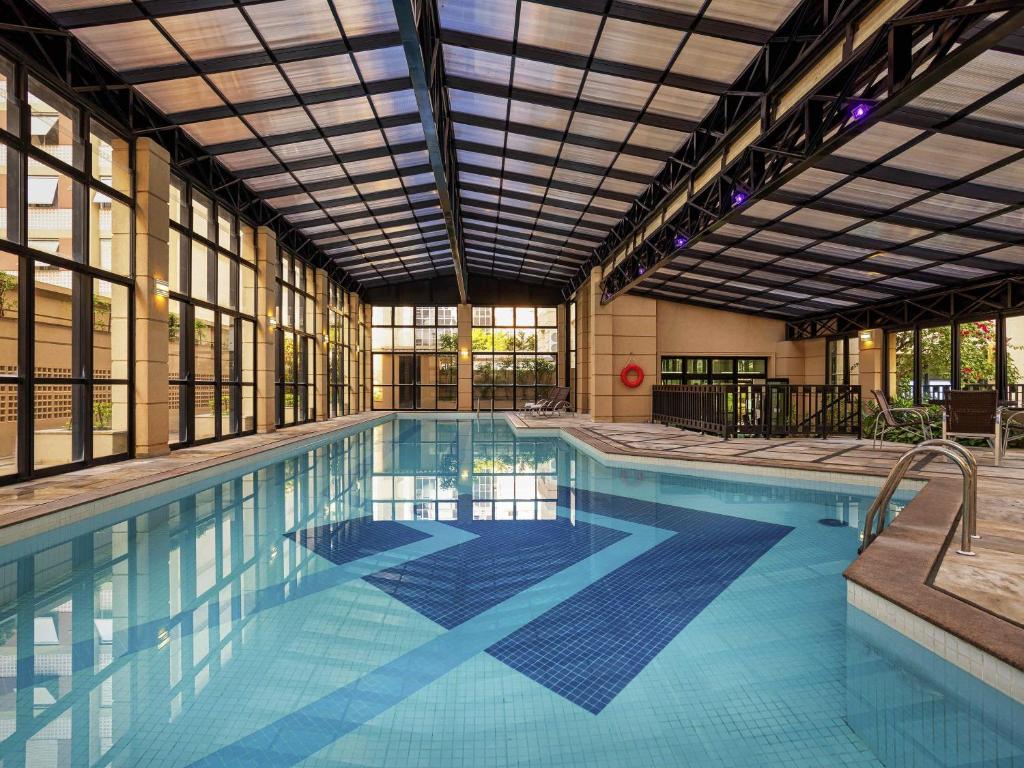 a large swimming pool with a large building at Mercure Sao Paulo Pinheiros in Sao Paulo