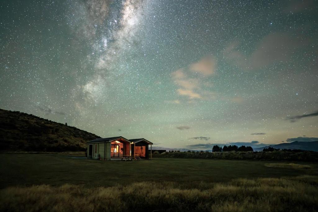 una cabaña en un campo bajo un cielo estrellado en Sleep under the stars at Manuka Starlight, en Twizel