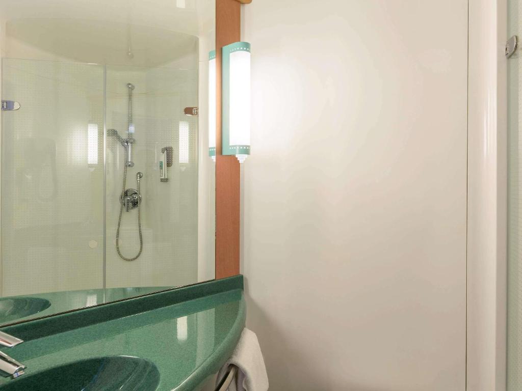 a bathroom with a green sink and a shower at ibis Besançon Centre la City in Besançon