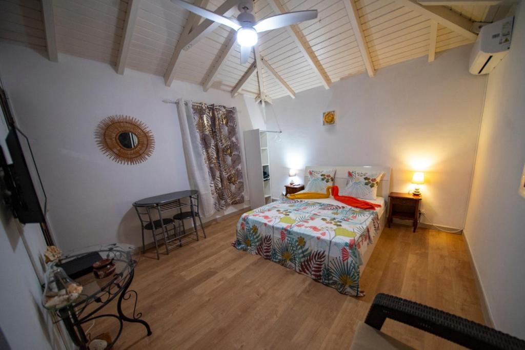 a bedroom with a bed and a ceiling fan at Studio Soleil Couchant in Pointe-Noire
