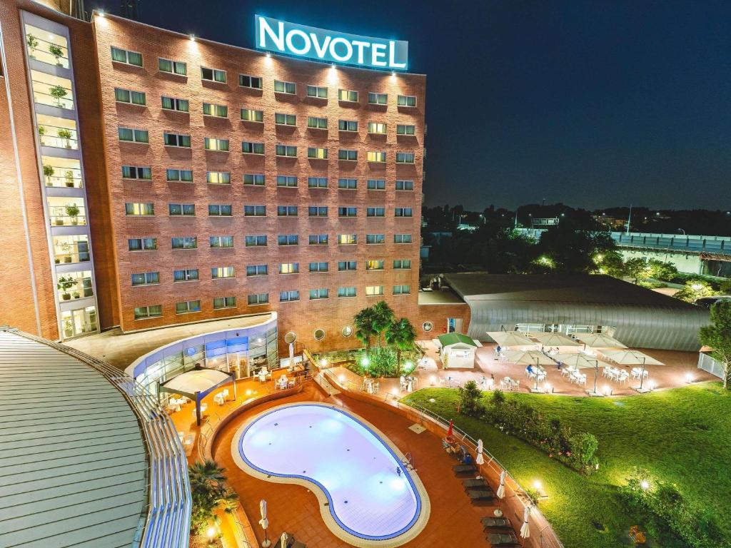 a hotel with a swimming pool in front of a building at Novotel Venezia Mestre Castellana in Mestre