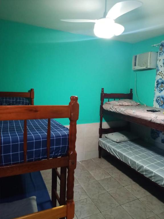 two bunk beds in a room with a green wall at Pousada costa in Paraty