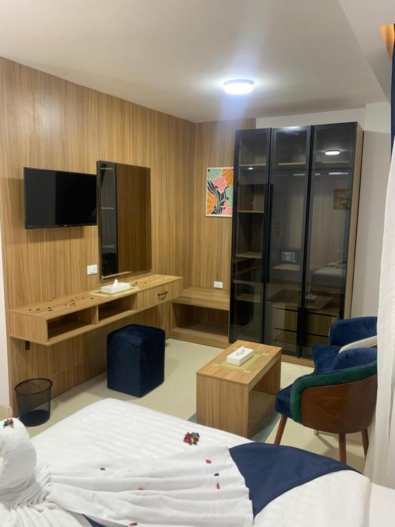 Una habitación de hotel con una cama y un televisor. en Kanz Pyramids Inn, en El Cairo