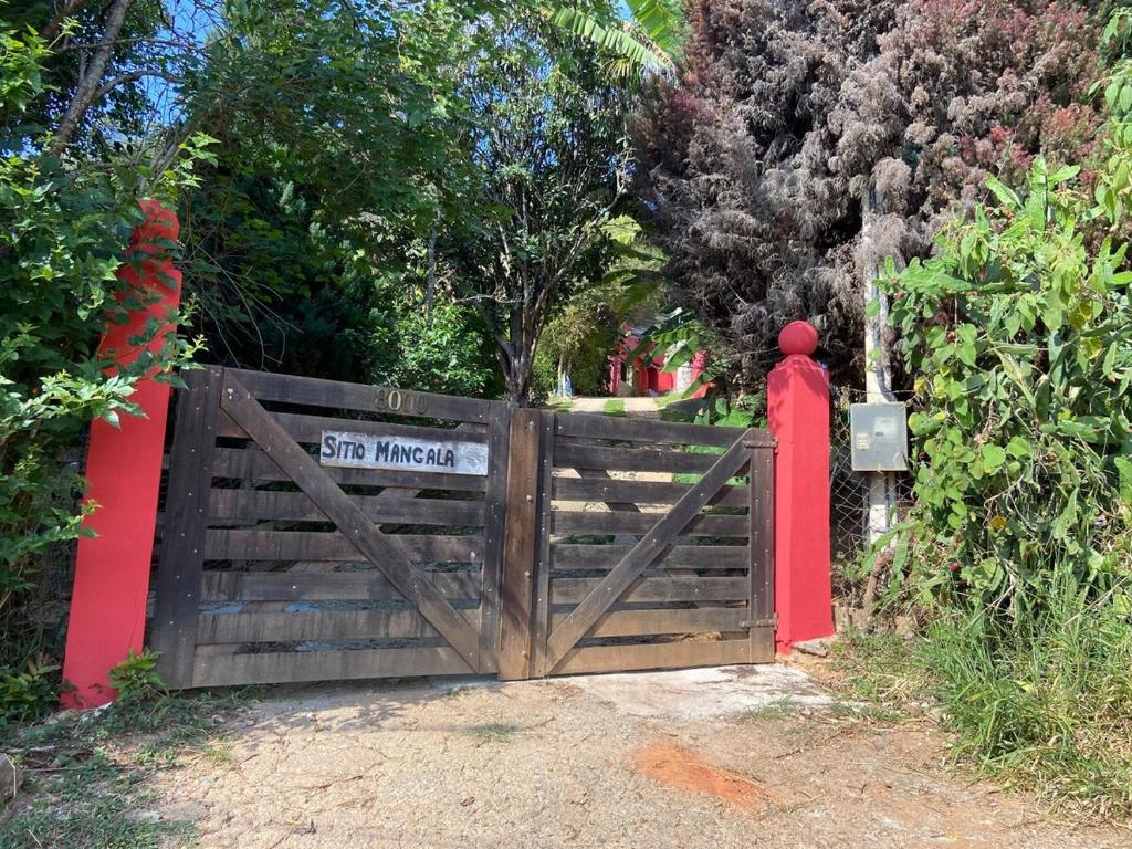 a wooden gate with a sign that reads stay magic at Sitio Mangala in Itapeva