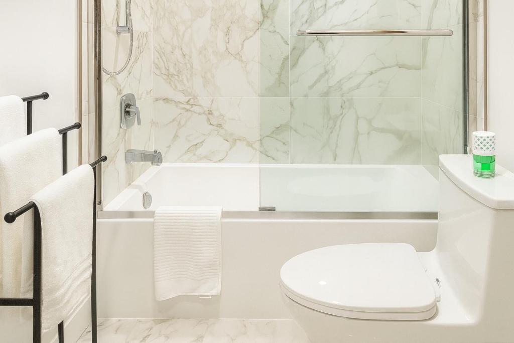 a white bathroom with a shower and a toilet at Deep Cove holiday in North Vancouver