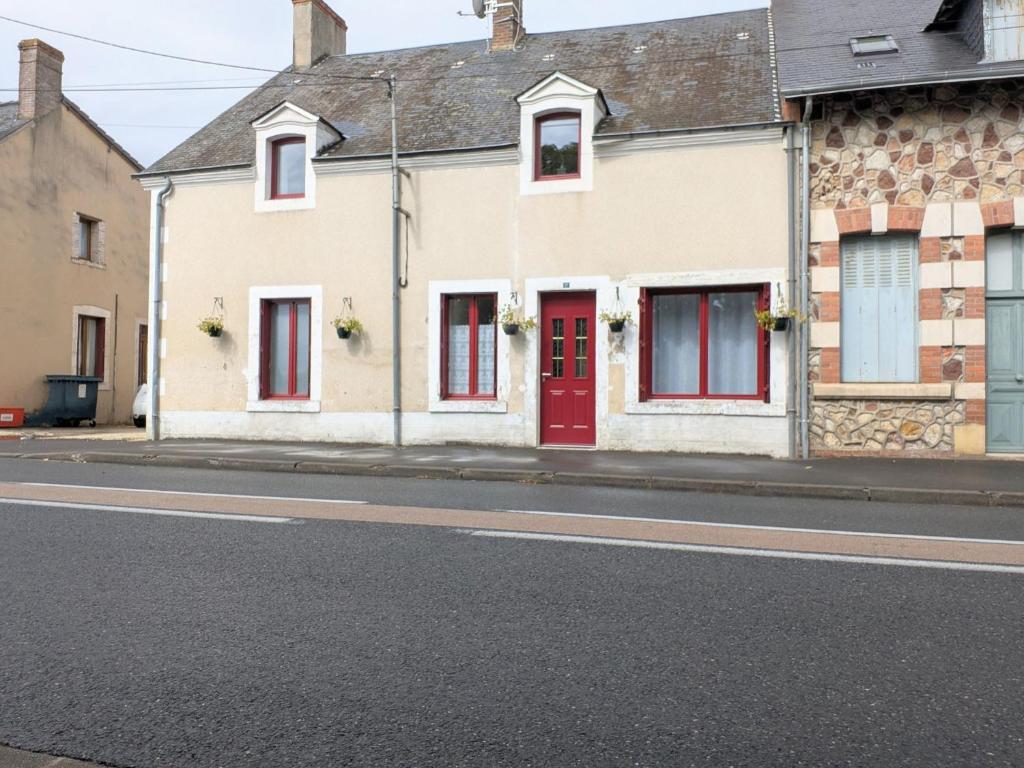 una fila di case con porte rosse su una strada di Maison spacieuse avec terrasse couverte et parking en région naturelle - FR-1-591-764 a Méobecq