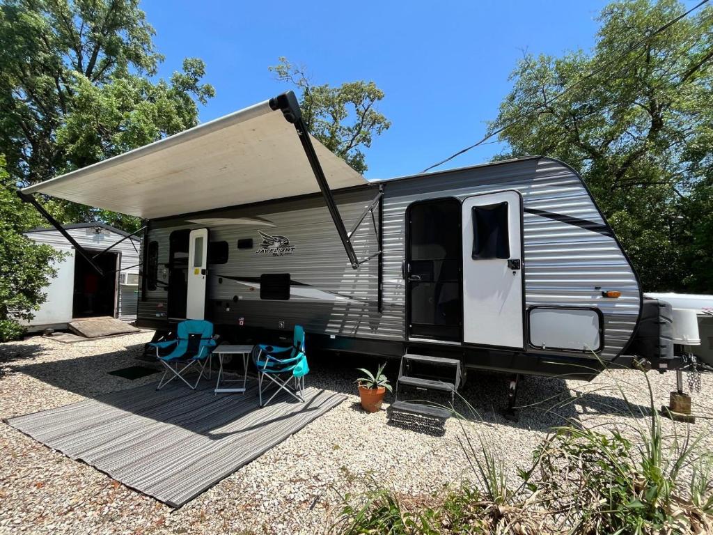 a trailer with a table and chairs in a yard at Comfortable 1BR RV for mid-to-long term stays in Beaumont