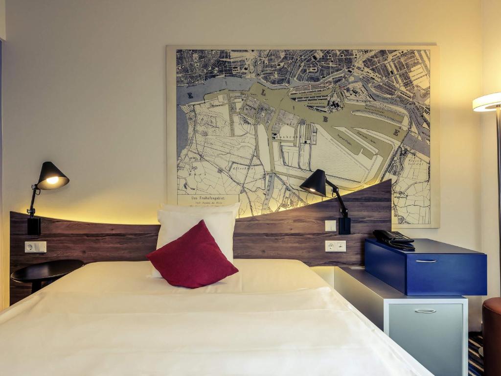 a bedroom with a bed and a map on the wall at Mercure Hotel Hamburg Mitte in Hamburg