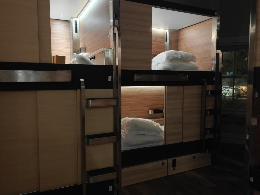a room with two bunk beds and a mirror at I Street Capsule Hostel in Washington, D.C.
