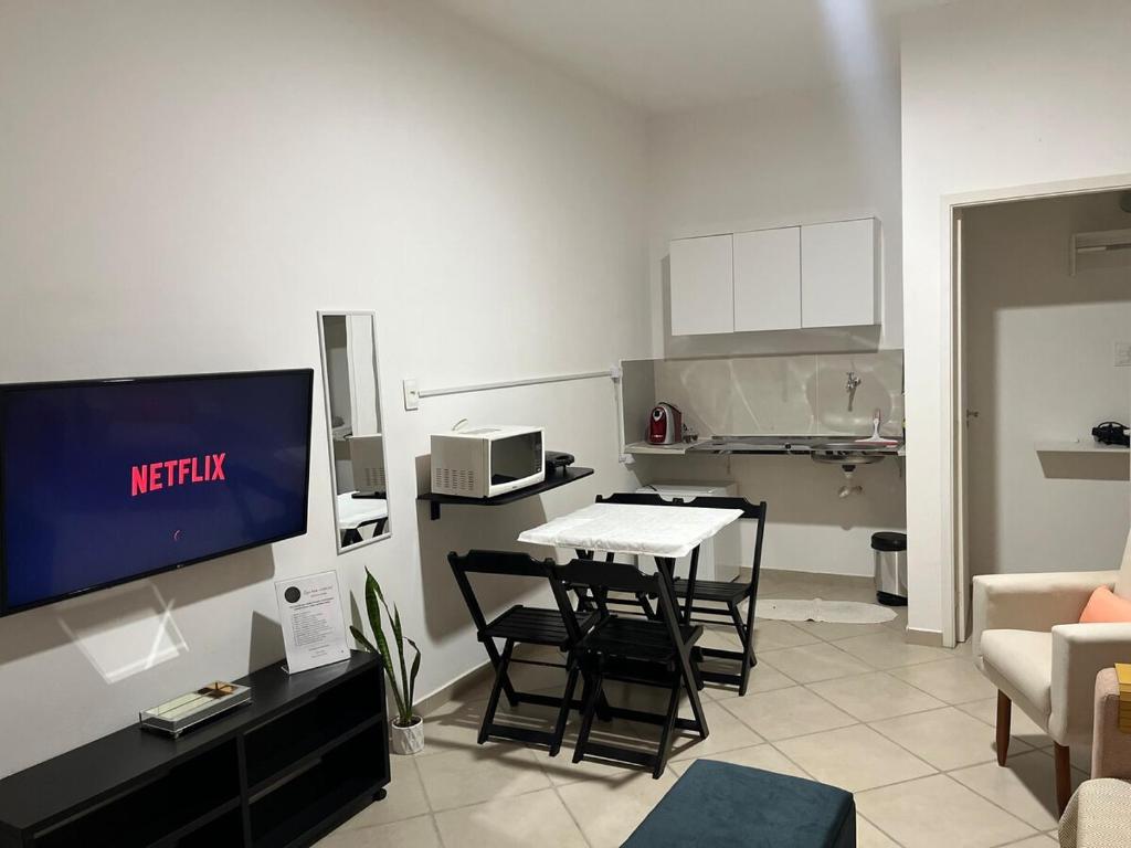 a living room with a tv and a table and chairs at Apartamento confortável centro de Sorocaba in Sorocaba