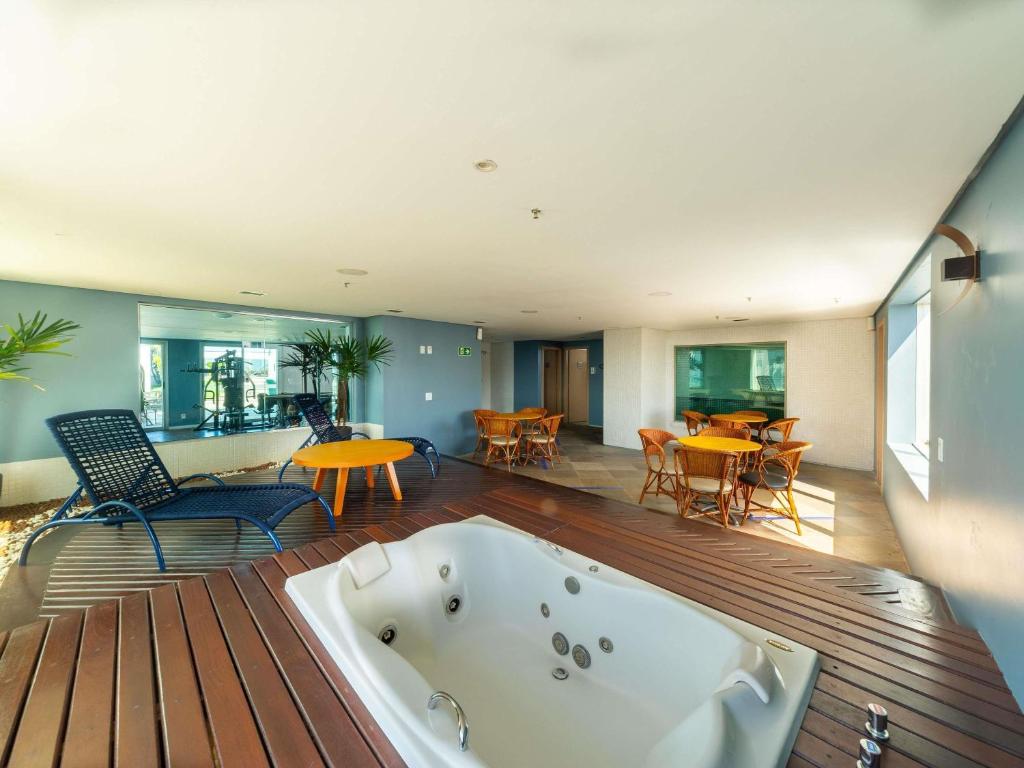 a bath tub sitting on a wooden floor in a room at Mercure Manaus in Manaus