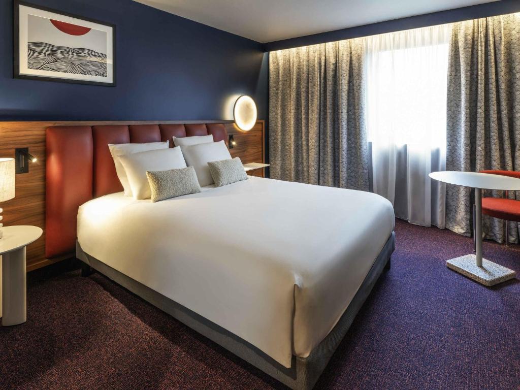 Un pat sau paturi într-o cameră la Mercure Caen Cote De Nacre