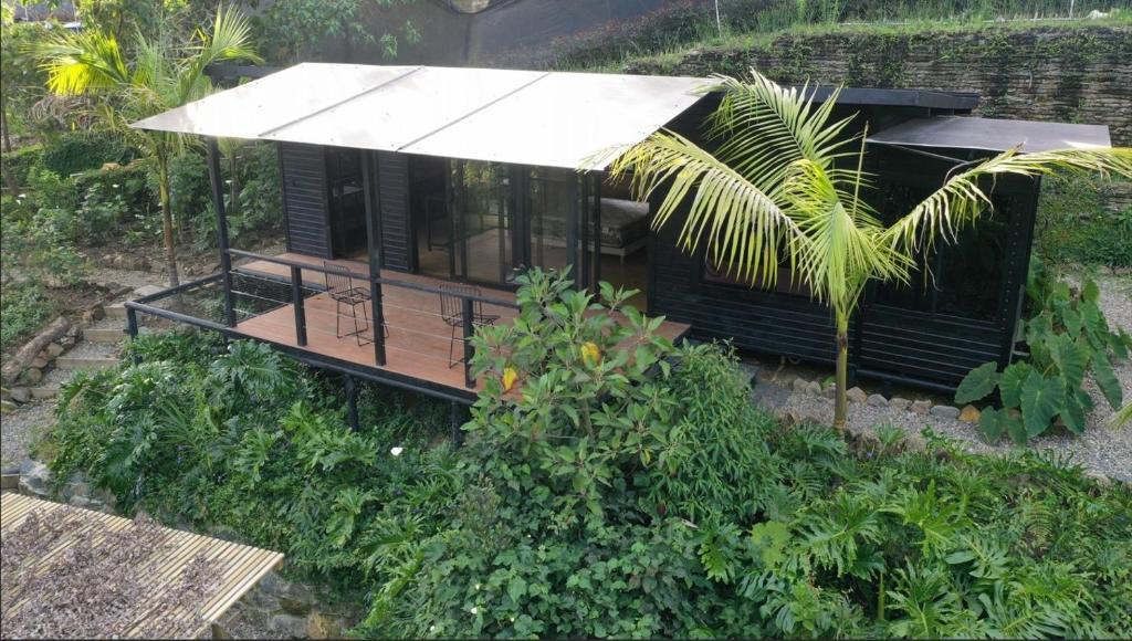 a small black house with a white roof at Refugio Madremonte in Medellín