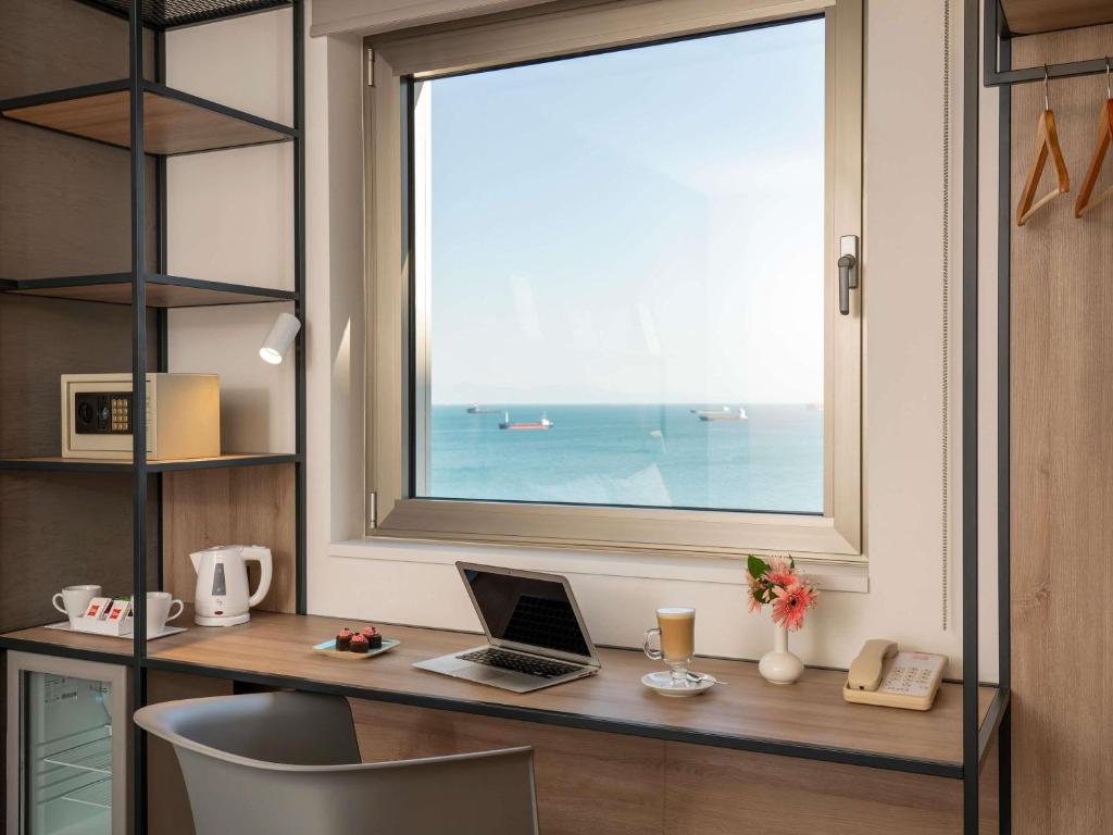 a desk with a laptop and a window at Ibis Istanbul Zeytinburnu in Istanbul