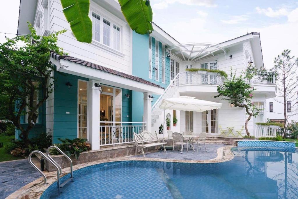 ein Haus mit einem Swimmingpool vor dem Haus in der Unterkunft Villa B82 Flamingo Đại Lải Resort in Phúc Yên