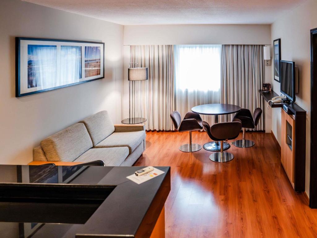a living room with a couch and a table at Novotel Lima San Isidro in Lima