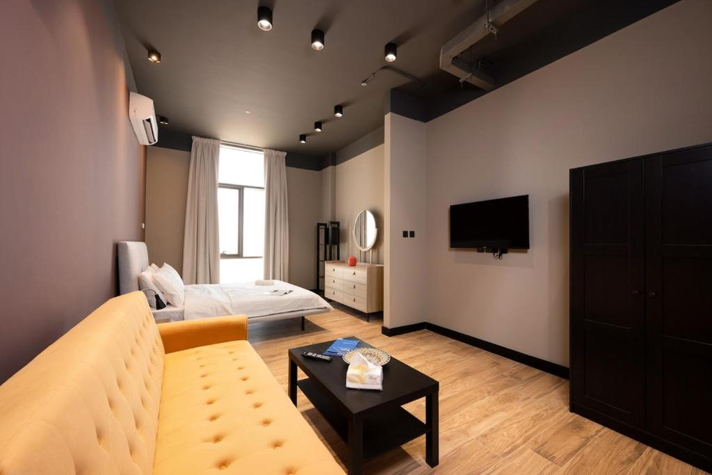a living room with a couch and a tv at Chic gateway Studio by Spacey Duqm 80 in Duqm
