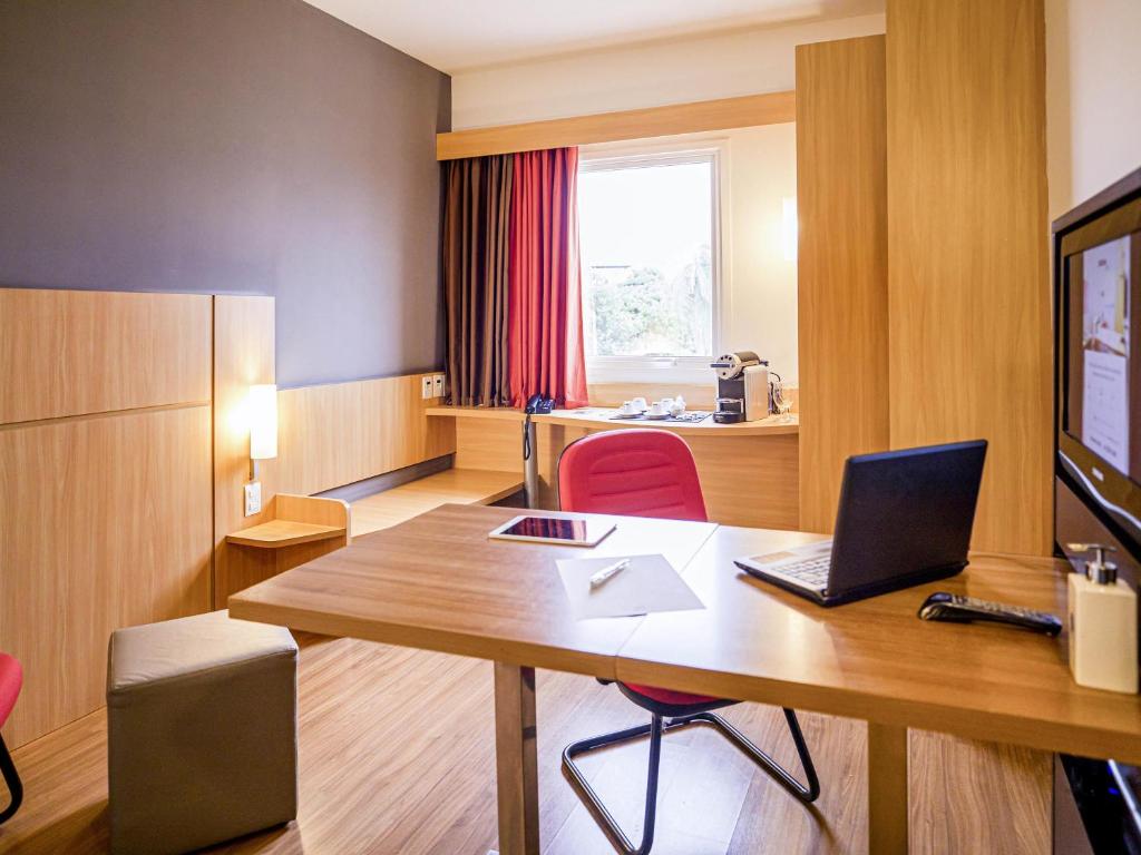 Una habitación con un escritorio con una computadora portátil encima. en ibis Petrolina, en Petrolina