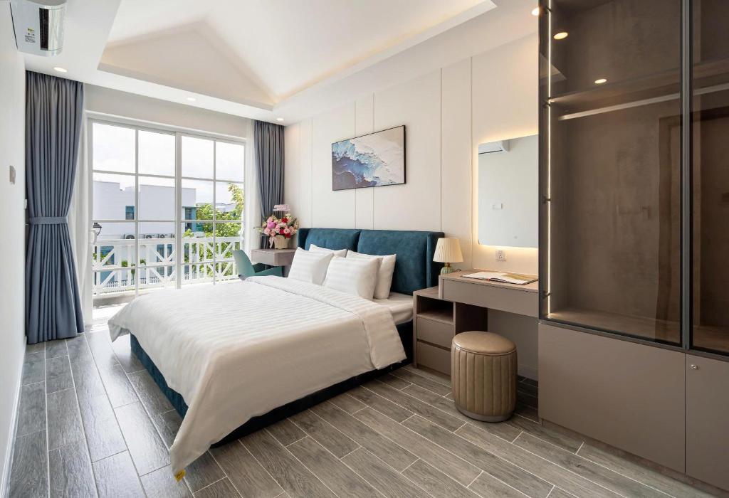 a hotel room with a large bed and a window at Zenda Villa Novaworld Phan Thiết in Bình Tú