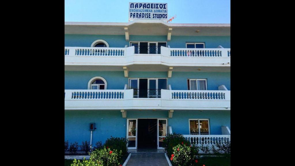 a blue building with a balcony on top of it at Paradise Studios in Faliraki