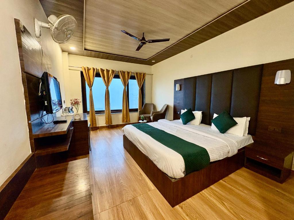 a hotel room with a bed and a television at Hotel The Zen Villa in Dalhousie