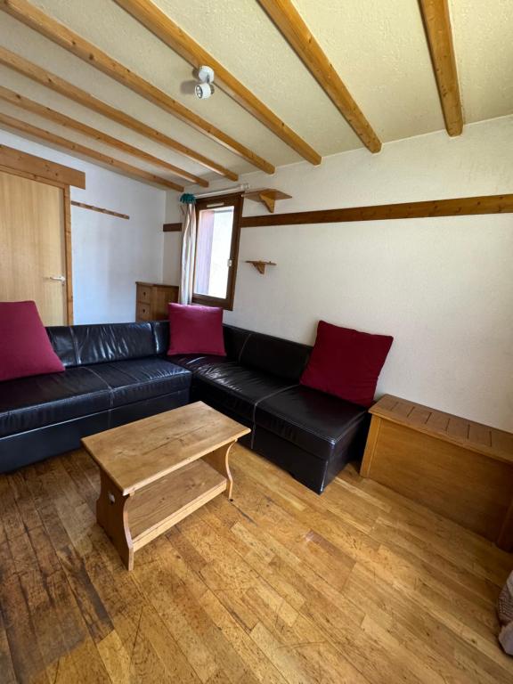 ヴァル・トランスにあるReinne Blanche Residence by Alpstaysのリビングルーム(黒い革張りのソファ、赤い枕付)