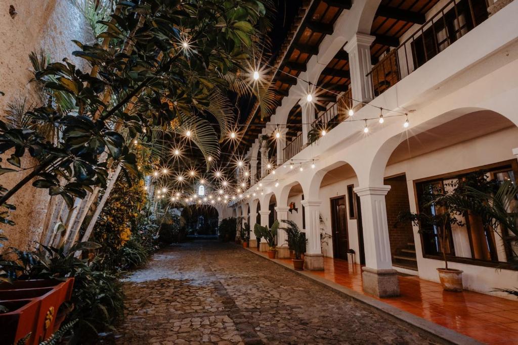a hallway of a building with plants and lights at Colonial House 8 rooms and private parking in Antigua Guatemala in Antigua Guatemala