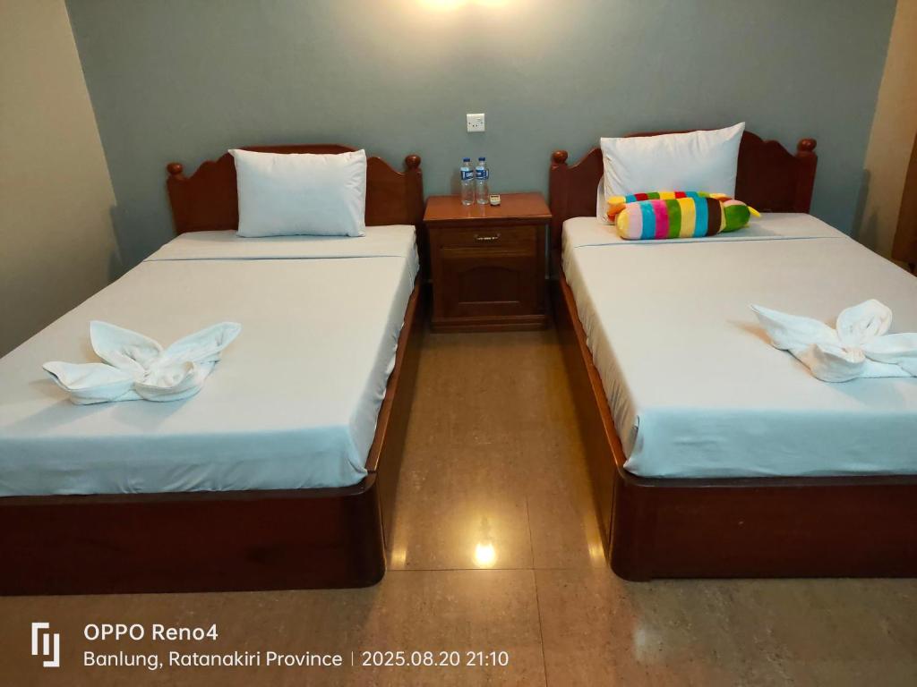 two beds in a room with towels on them at C T hotel in Banlung