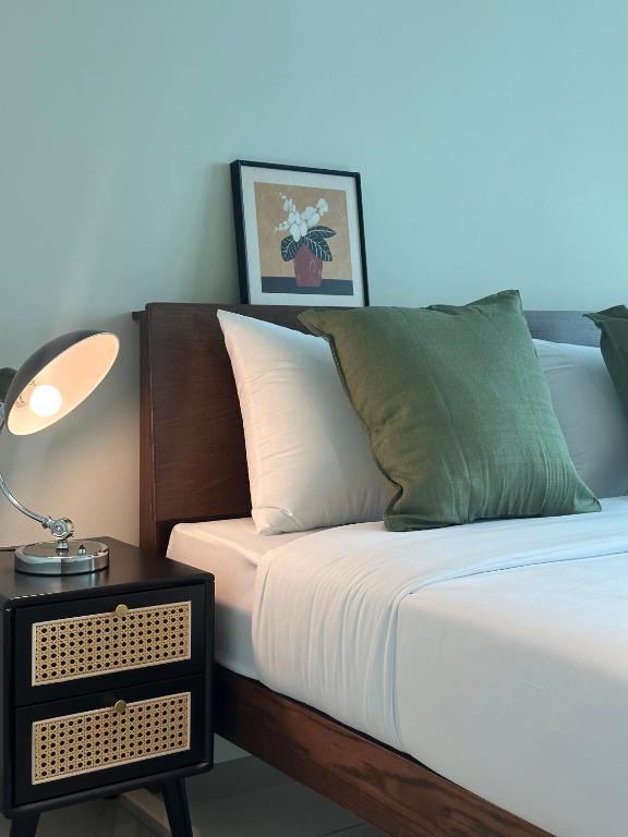 a bed with a side table with a lamp on it at Metropol by BRB in Bukit Mertajam
