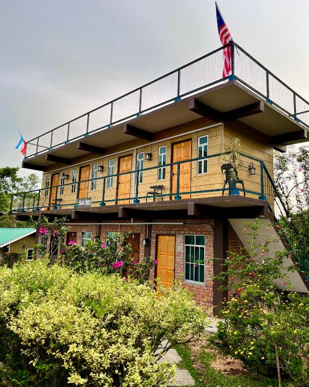 a building with a balcony with an american flag on it at LY Lodge in Bundu Tunan