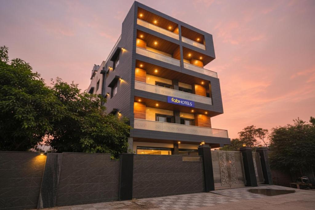 un edificio alto con un tramonto sullo sfondo di Via Vibe a Noida